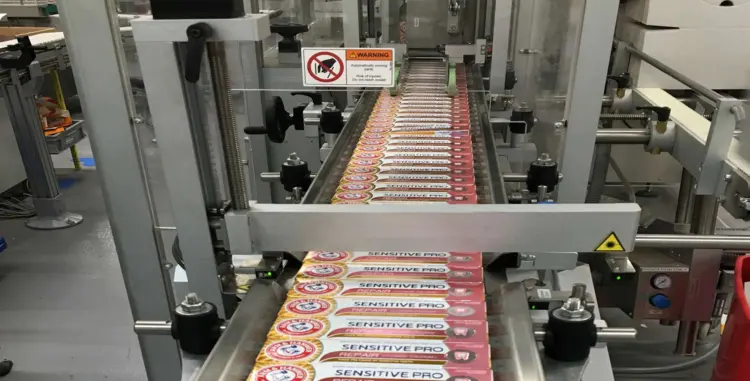 A conveyor belt transporting a series of neatly arranged products.
