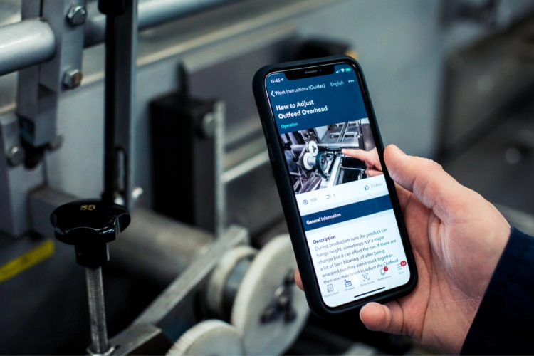 A person holding a phone with Poka connected worker platform on the screen.