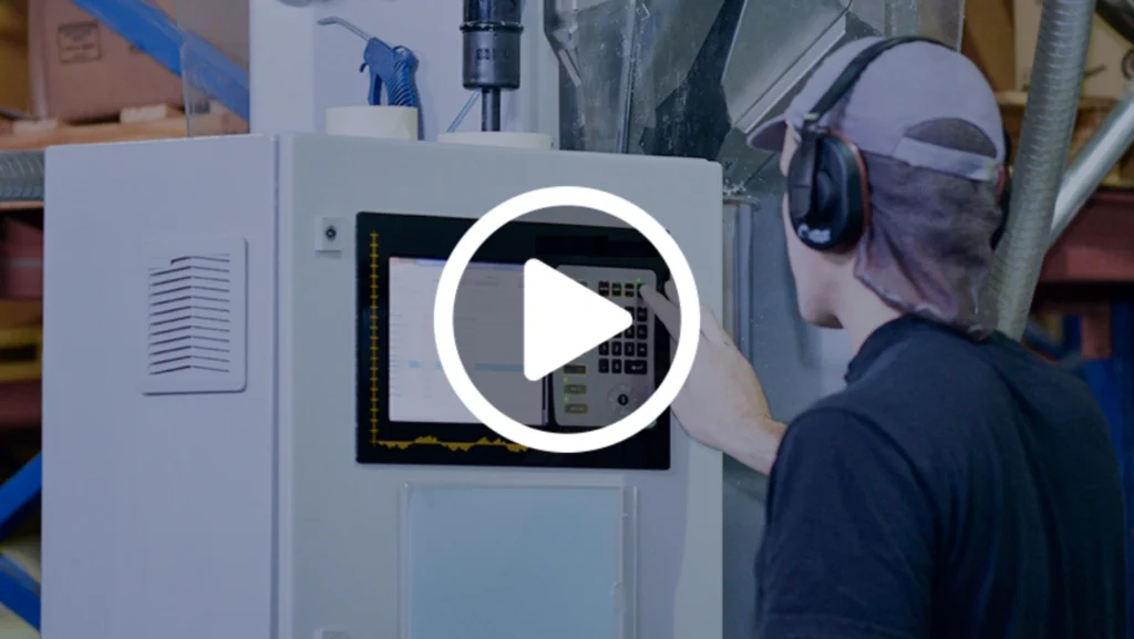 A man operates a machine, focused on his task in a modern workspace.