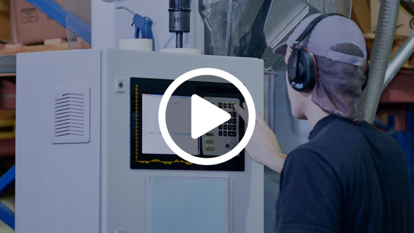 A man operates a machine, focused on his task in a modern workspace.