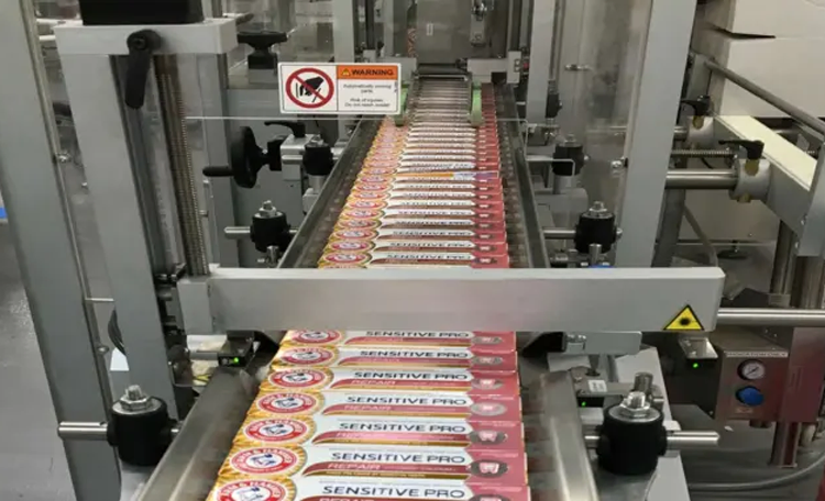 A conveyor belt transporting a series of neatly arranged products.