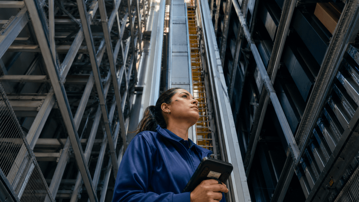 A person with a mobile device in hand walking in a factory