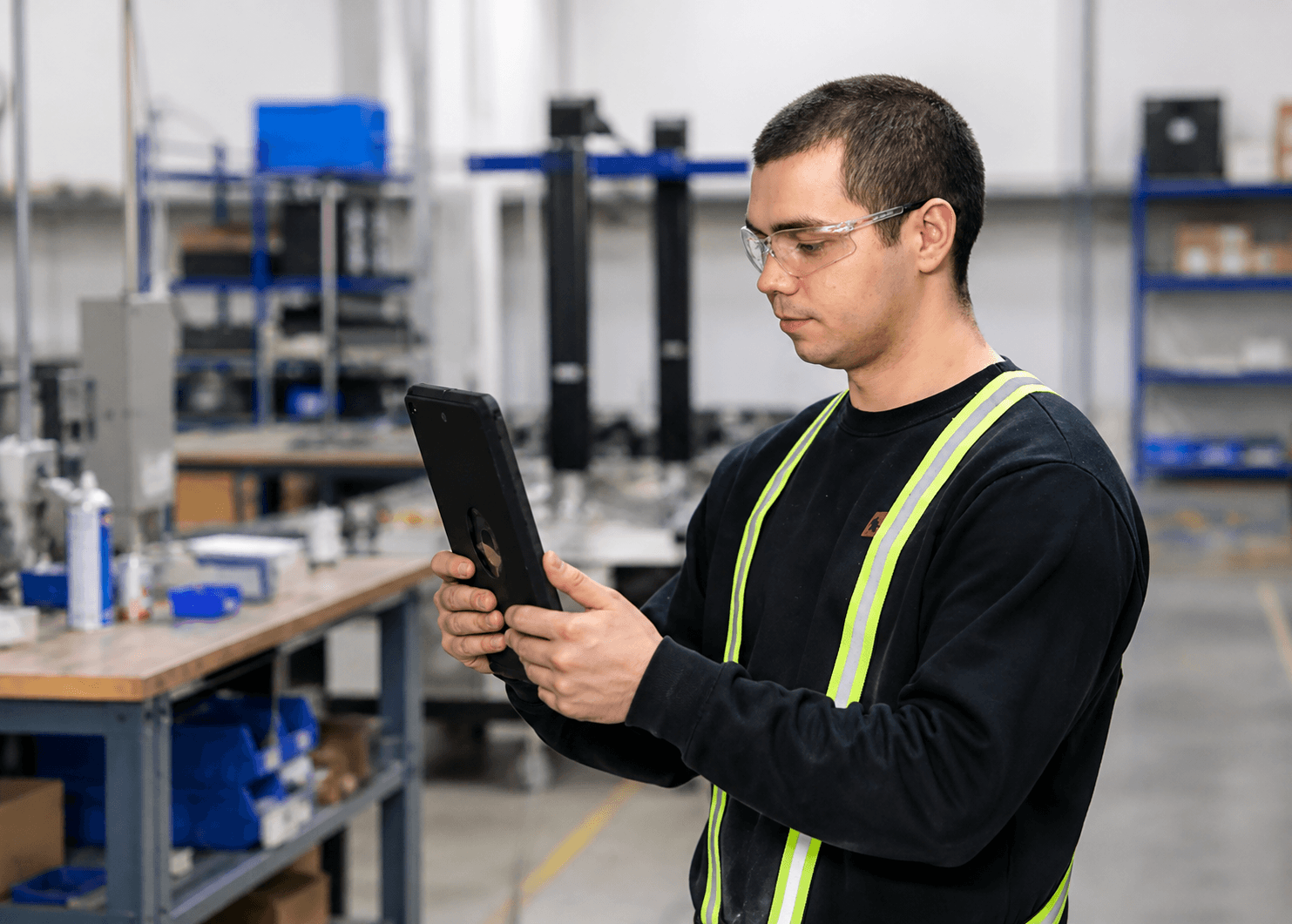 worker holding tablet (1) A worker wearing safety glasses looking at a tablet